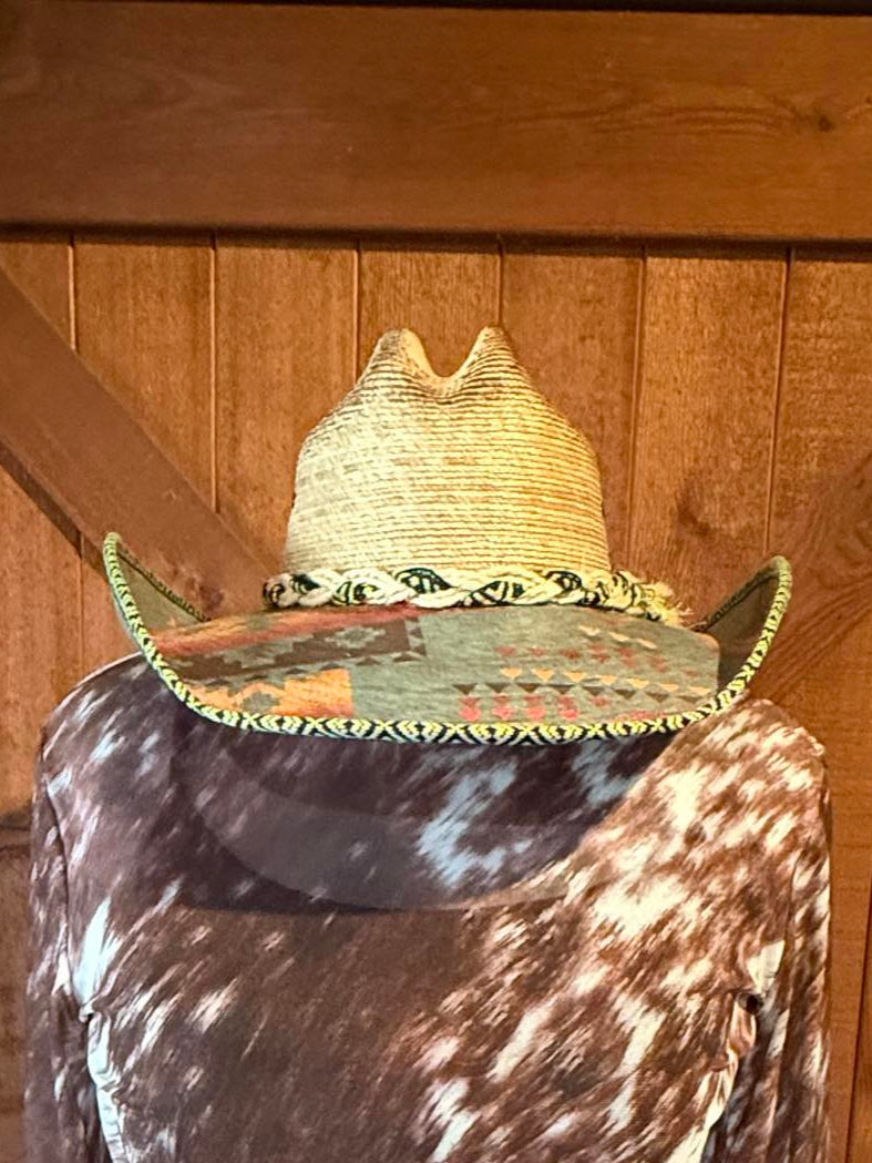 Natural straw western hat with turquoise and black tribal print under brim and braided trim.