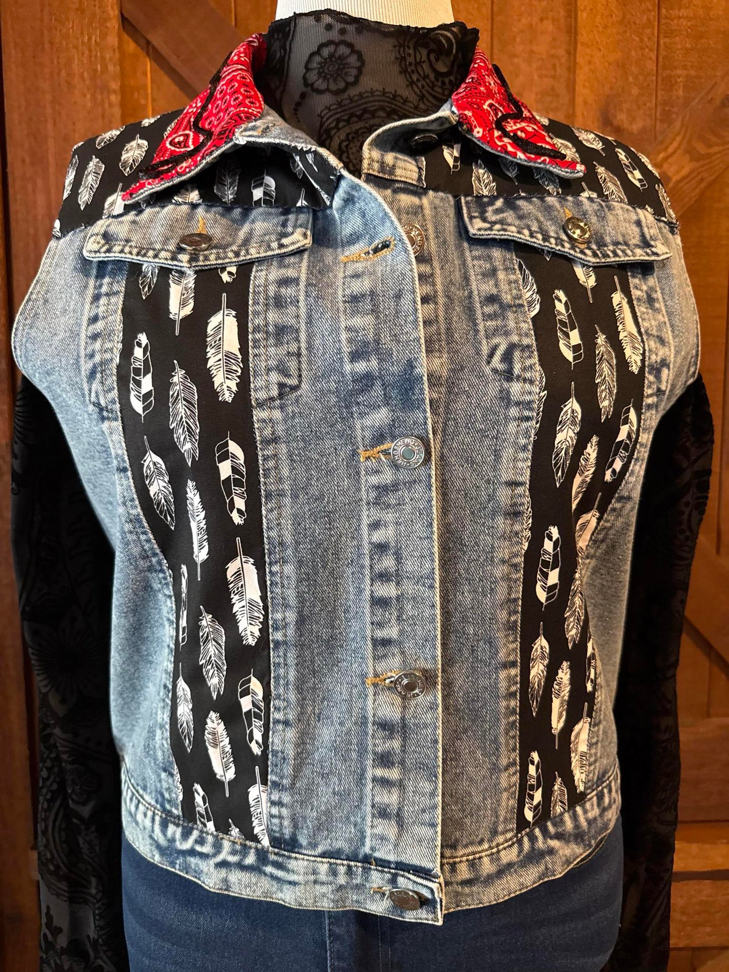 Hand-embellished denim jacket with black and white feather-print fabric panels and red bandana collar, designed by Cindy Owen in Brooksville, Florida.