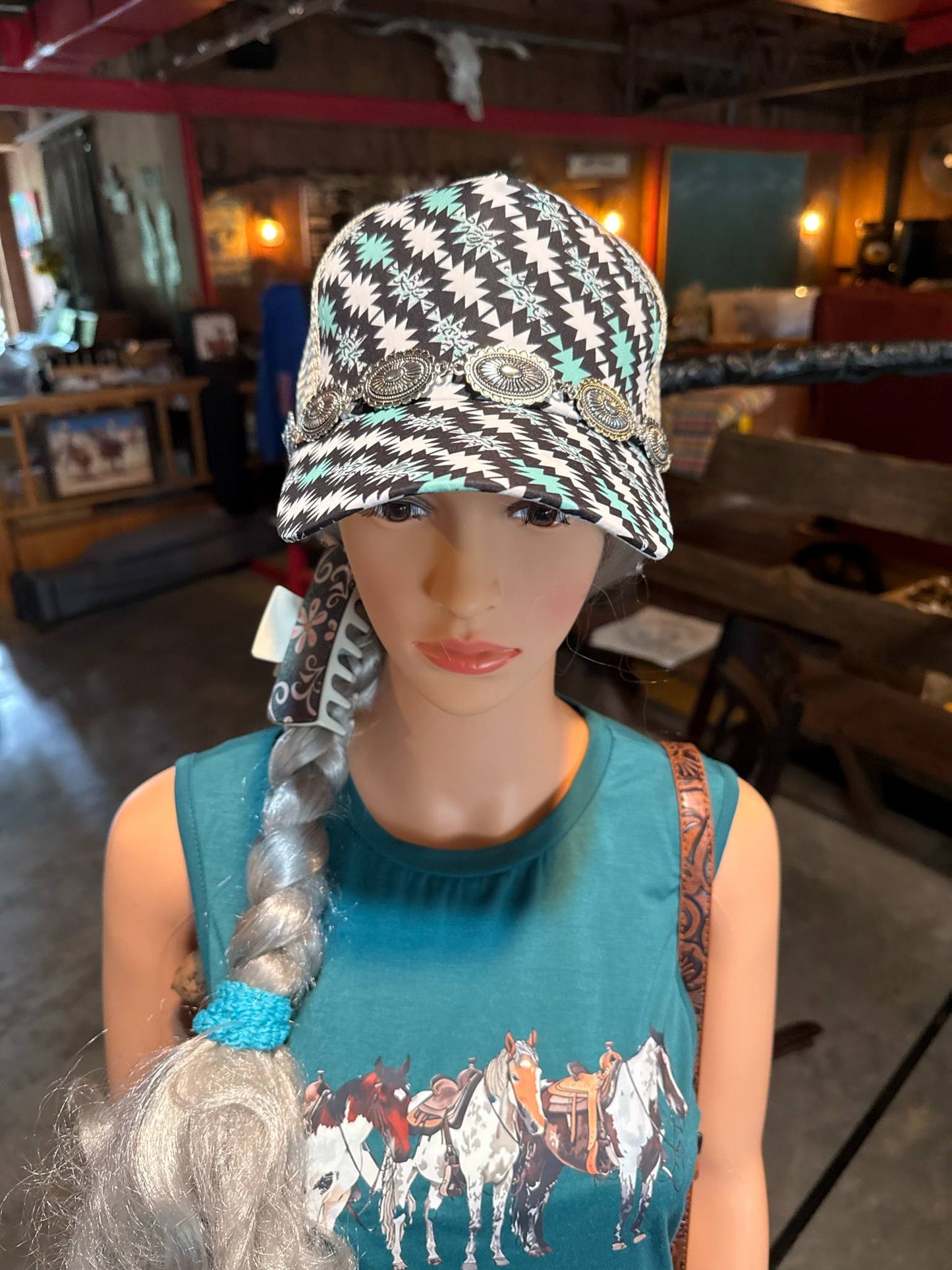 Southwestern print baseball cap in black, white, and turquoise with silver concho embellishments across the front