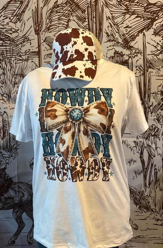 "White t-shirt featuring a turquoise 'Howdy' graphic and a cowprint bow design for a fun western vibe."