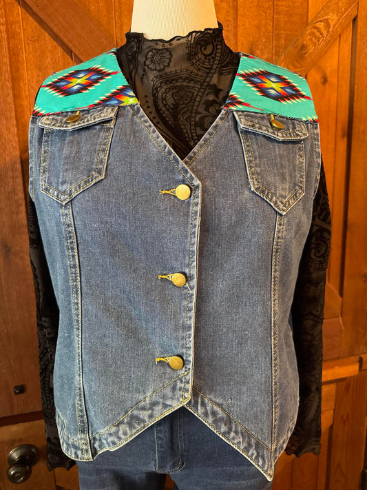Sleeveless denim vest with turquoise southwestern-print fabric on the front and back yoke, brass button closure, and pointed hem. Handmade and one of a kind in size 2XL.