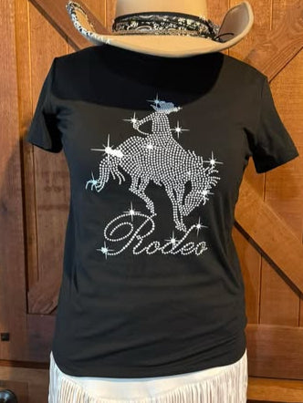 Black short sleeve t-shirt with rhinestone rodeo rider and starburst design, paired with a white fringe skort.