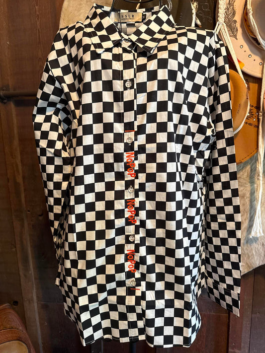 Black and white checkered NoPop barrel racing shirt, medium size, with secure hidden closure to prevent snagging while riding.