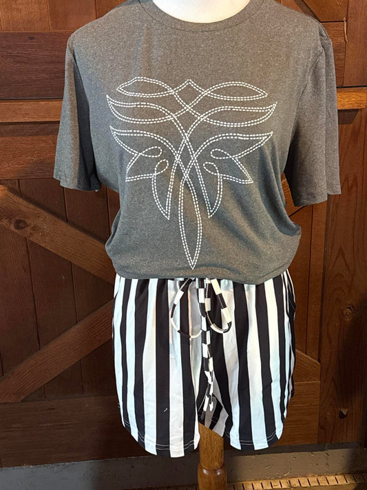 Heather gray short sleeve t-shirt featuring a white stitched western boot-inspired graphic design across the chest, styled with black and white striped drawstring shorts on a mannequin.
