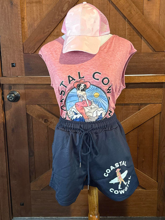Sleeveless pink tank top featuring a vintage-style graphic of a cowgirl in a mermaid tail under a coastal sun, with the words "Coastal Cowgirl" encircling the design.
