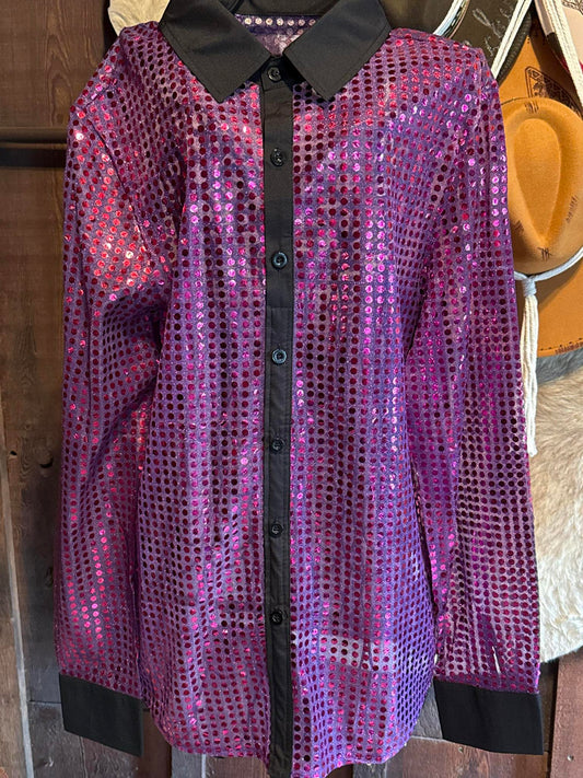 Sheer and shimmering long sleeve sequin button-up shirt in electric pink and purple hues with black cuffs and collar, hanging against a rustic wooden background.