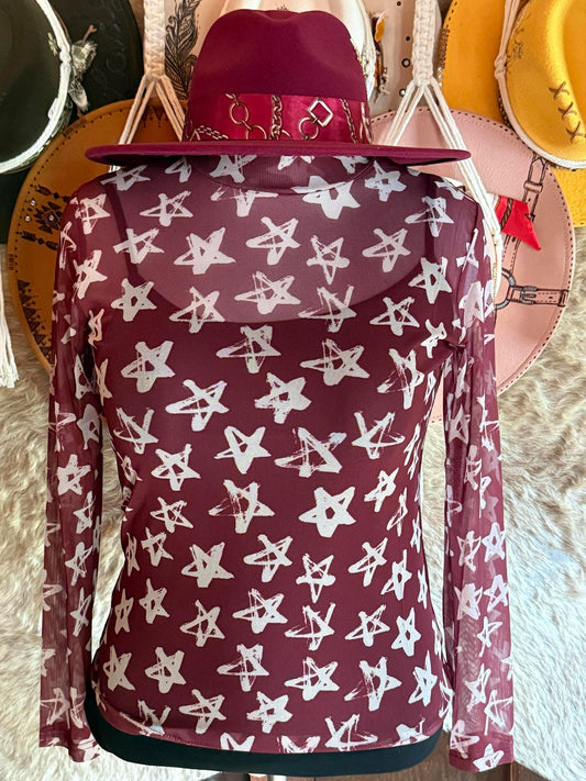 Burgundy long-sleeve mesh top with white hand-drawn star pattern, displayed on a mannequin wearing a matching wide-brim hat.