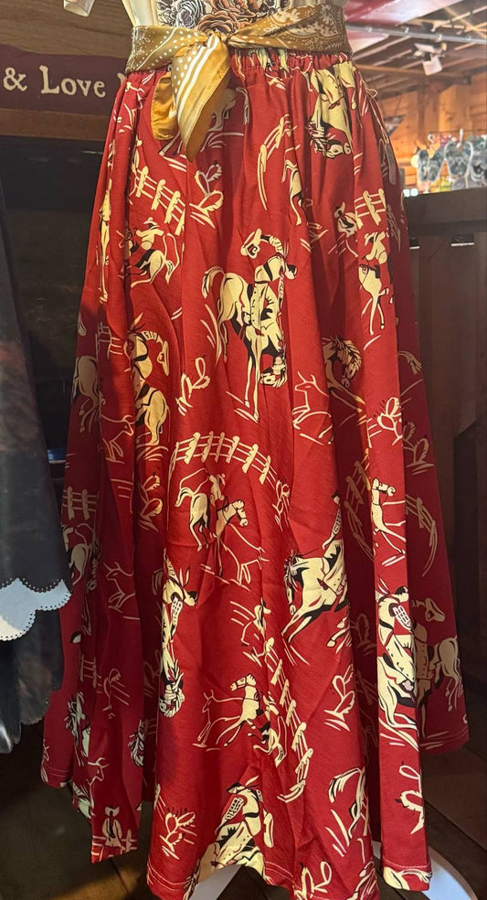 Vintage-inspired red midi skirt with cream and black bucking bronco print, shown styled with a western tee and bandana belt