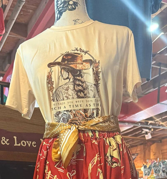 Cream-colored graphic t-shirt (size medium) featuring a cowgirl with a braid and hat, framed by floral accents and the phrase "Perhaps you were born for such a time as this"